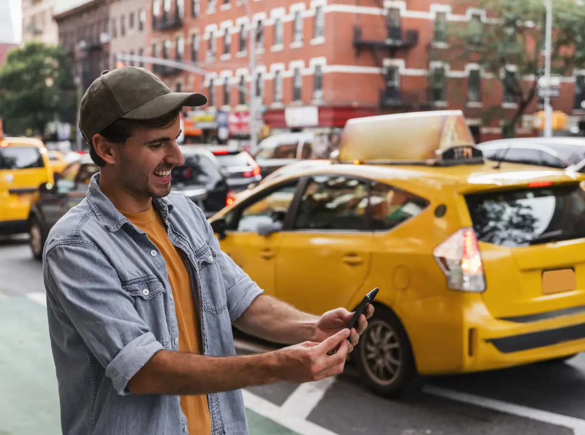 Smiling passenger checking Excel Taxi Yeovil booking details on his phone